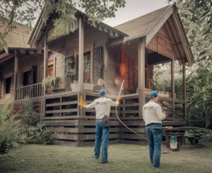 Two people cleaning a wooden house